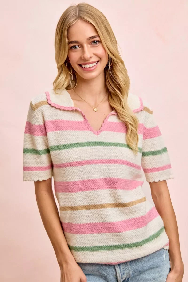 Woman wearing a pink, green, and beige striped knit short sleeve top with scalloped collar