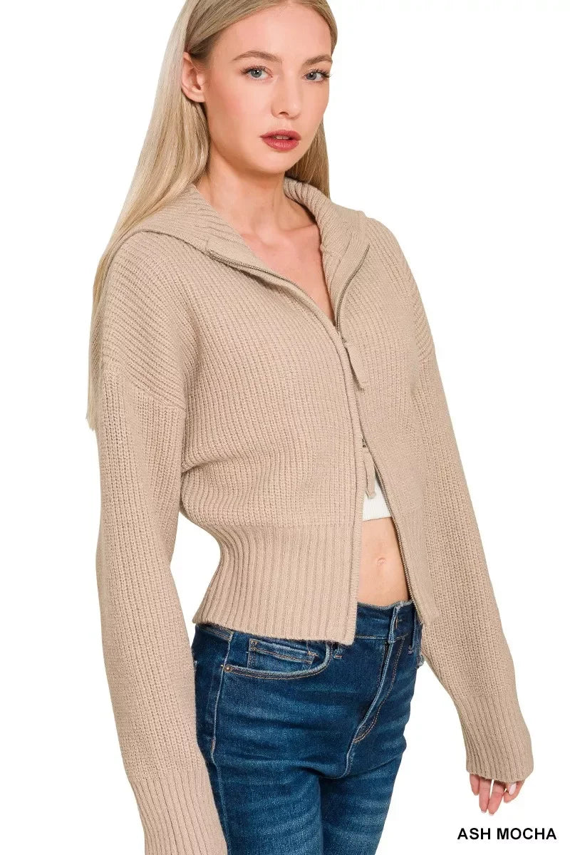 Woman wearing ash mocha ribbed knit zip-up sweater with hood and high-waisted jeans