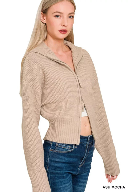 Woman wearing ash mocha ribbed knit zip-up sweater with hood and high-waisted jeans