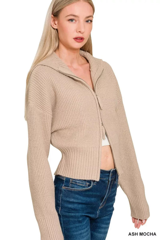 Woman wearing ash mocha ribbed knit zip-up sweater with hood and high-waisted jeans