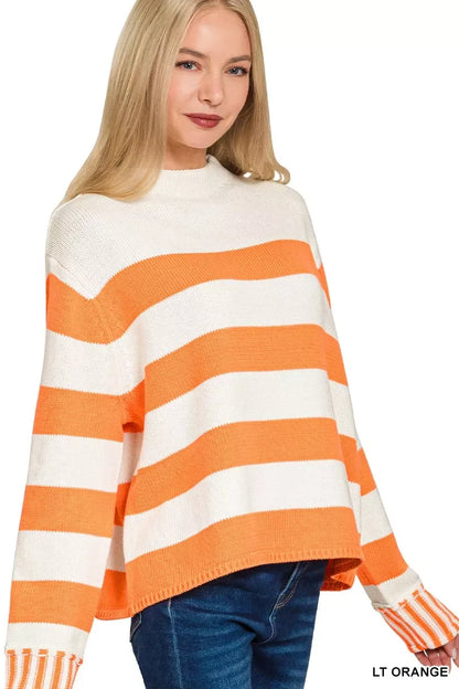 Woman wearing a relaxed-fit, orange and white striped knit sweater with long sleeves
