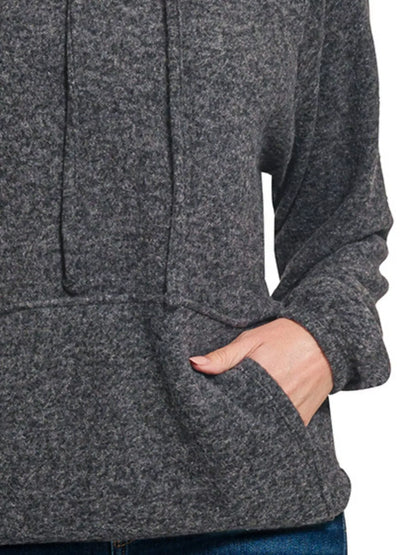 Woman wearing a cozy charcoal grey pullover hoodie with front pocket and relaxed fit