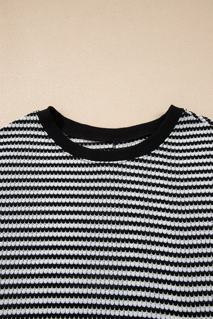 Black and white striped knit top with crew neckline, textured ribbed pattern