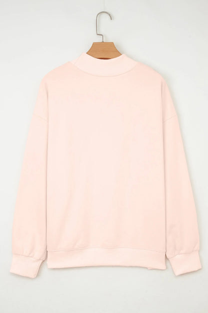 Back view of pale pink women’s pullover sweatshirt with ribbed cuffs and collar on hanger