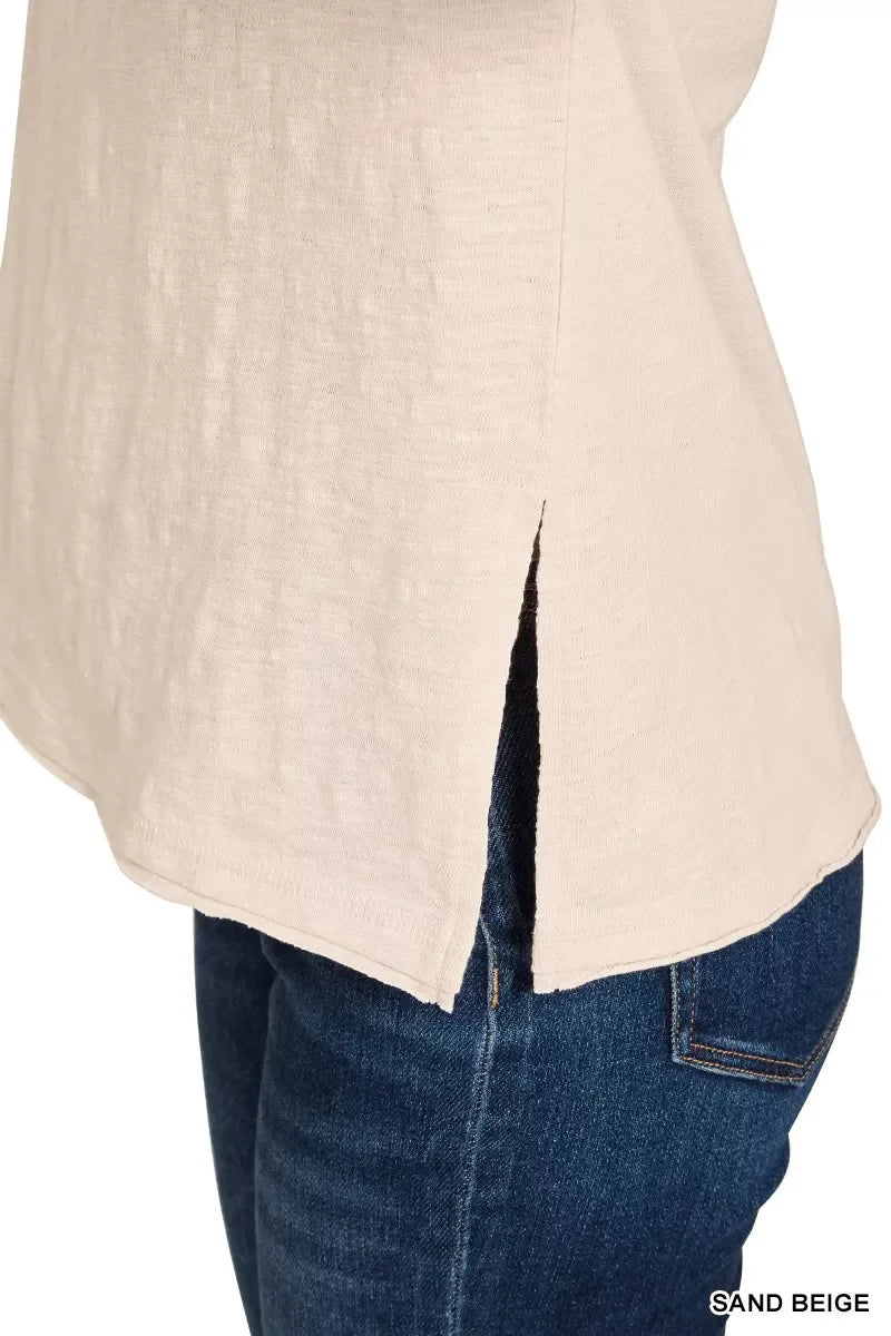 Sand beige women’s top with side slit hem, paired with dark blue denim jeans