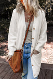 Woman wearing a long white cardigan, striped top, jeans, and brown leather crossbody bag outdoors