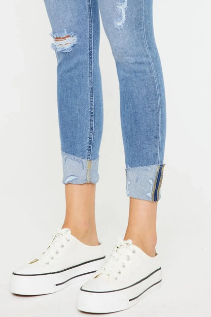 Distressed light wash cuffed skinny jeans paired with white platform sneakers