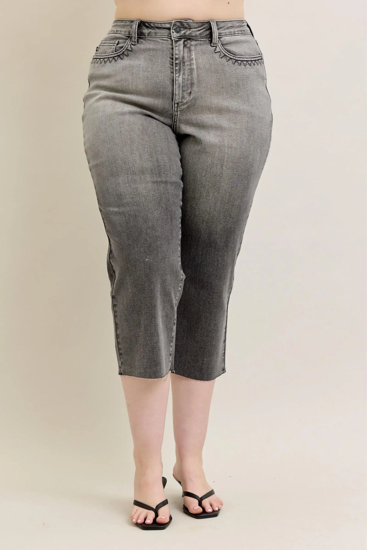 High-waisted grey cropped jeans with scallop pocket detail, styled with black sandals.