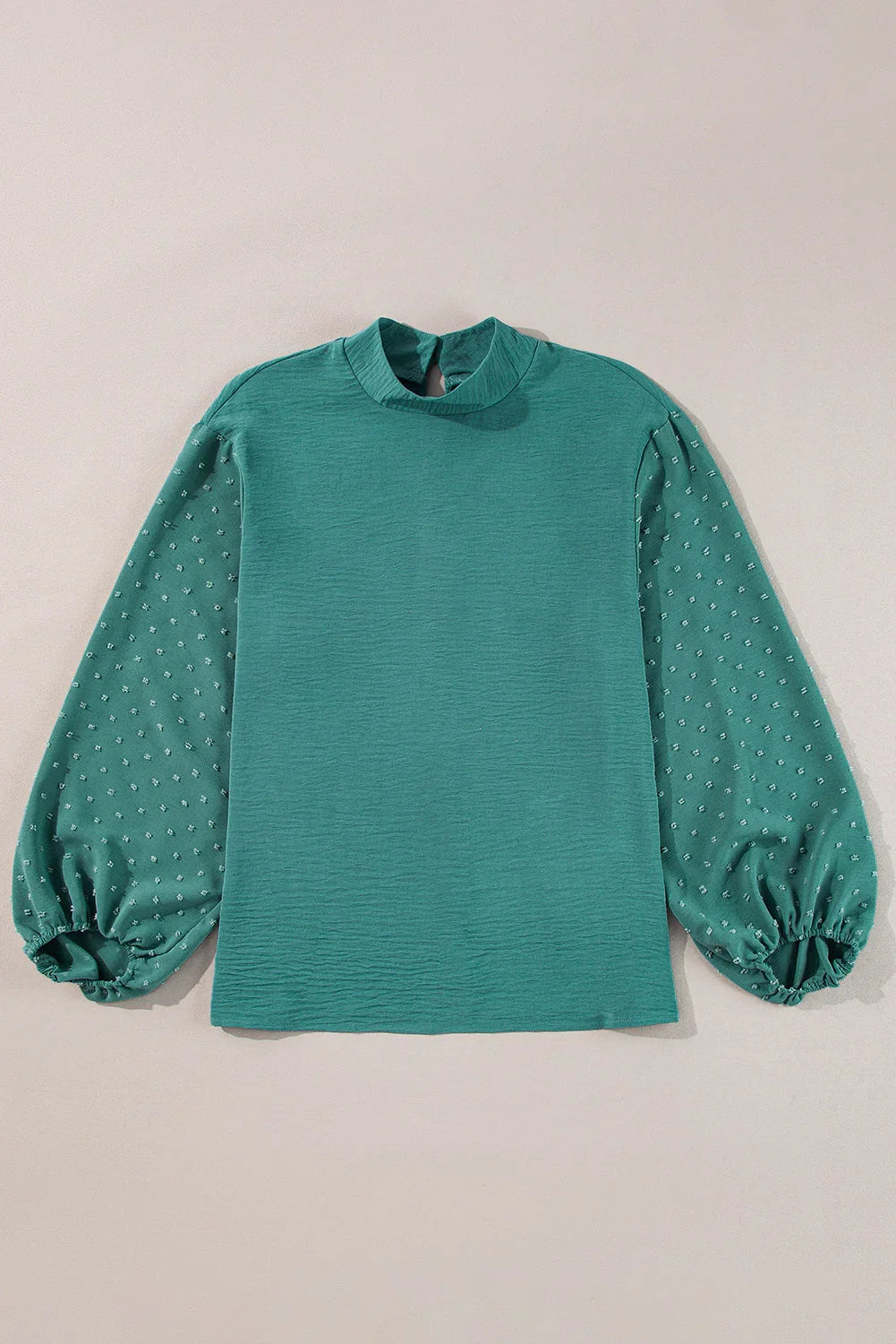Teal blouse with textured long puff sleeves and a mock neck, laid flat on neutral background
