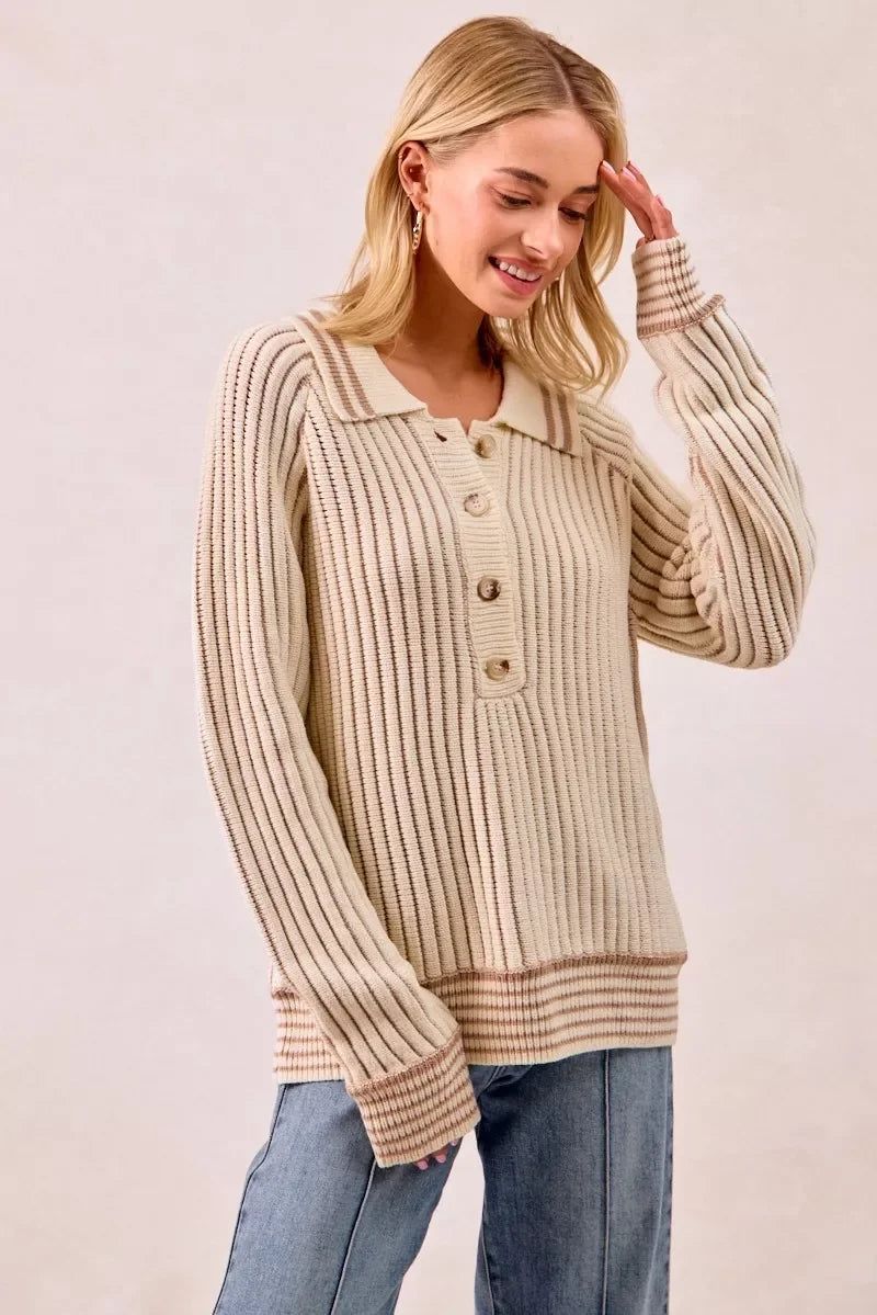 Woman in a cream ribbed knit button-up sweater with collar and relaxed blue jeans