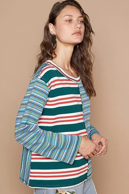 Woman wearing colorful striped long-sleeve top with relaxed fit and statement earrings