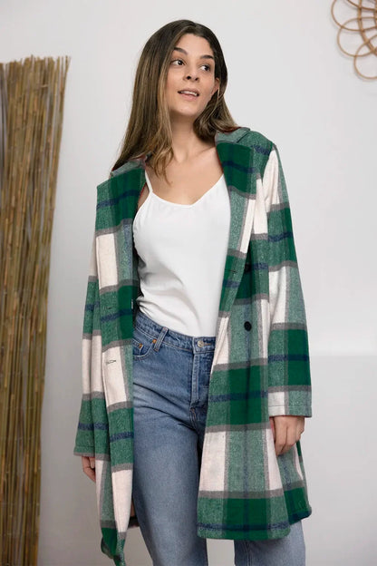 Woman in green plaid coat, white tank top, and blue jeans, modern casual outfit