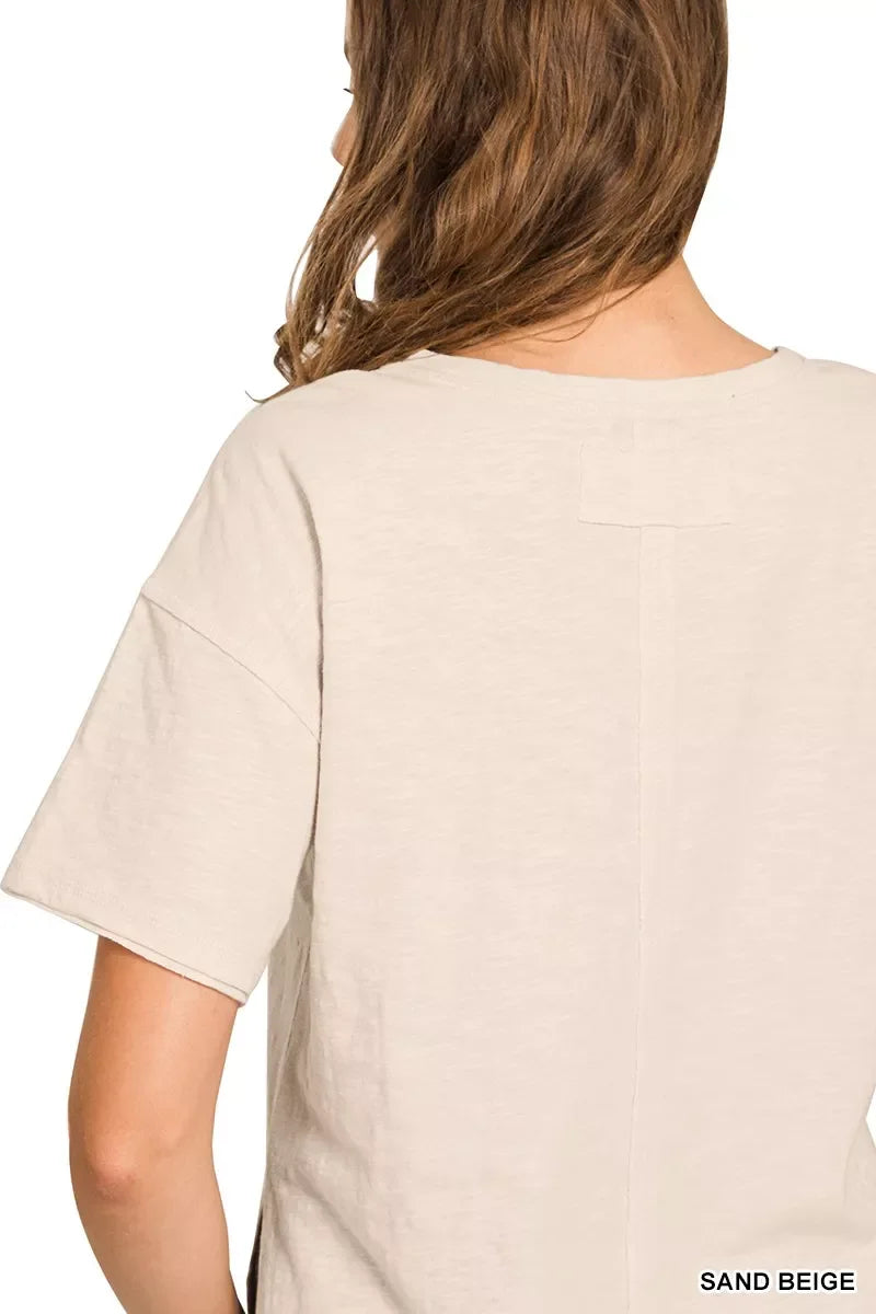 Back view of a woman wearing a relaxed fit sand beige short sleeve top