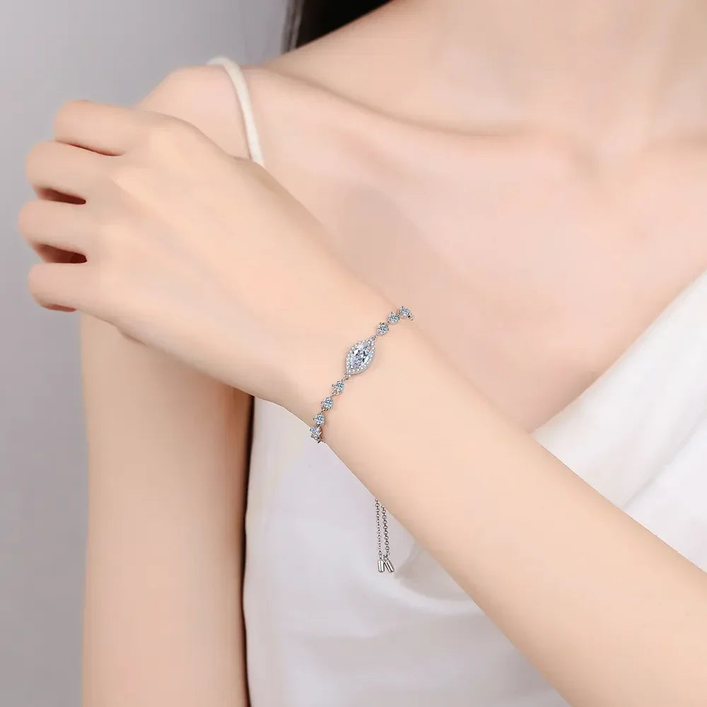 Delicate silver bracelet with sparkling crystal stones on woman's wrist, white sleeveless top