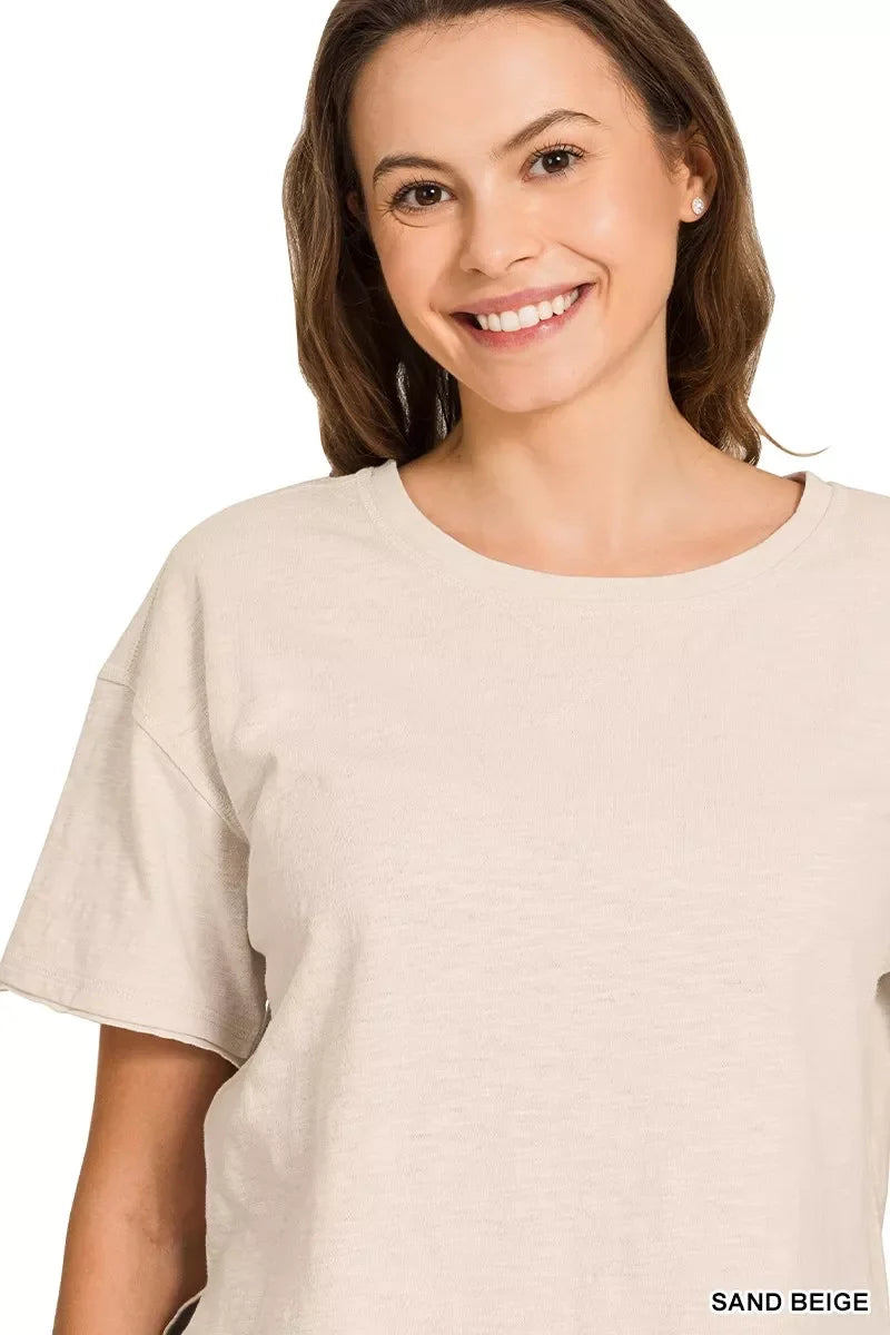 Woman wearing relaxed sand beige short sleeve t-shirt with crew neckline.