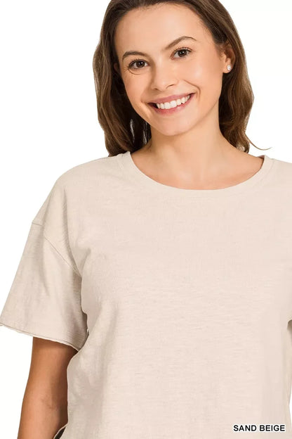 Woman wearing relaxed sand beige short sleeve t-shirt with crew neckline.