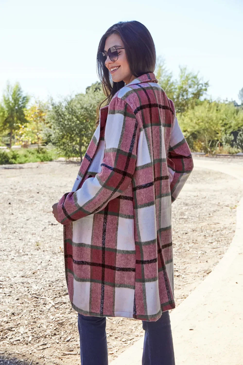Woman wearing a pink and green plaid long coat outdoors, casual fall fashion