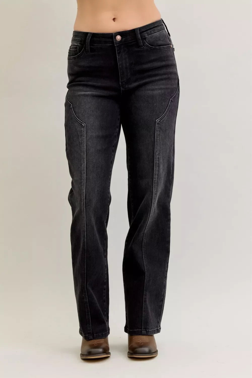 High-waisted black straight-leg jeans with front seam detail, styled with brown shoes.