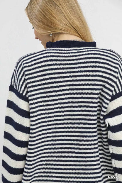 Back view of woman wearing navy and white striped knit sweater, blonde hair, casual style