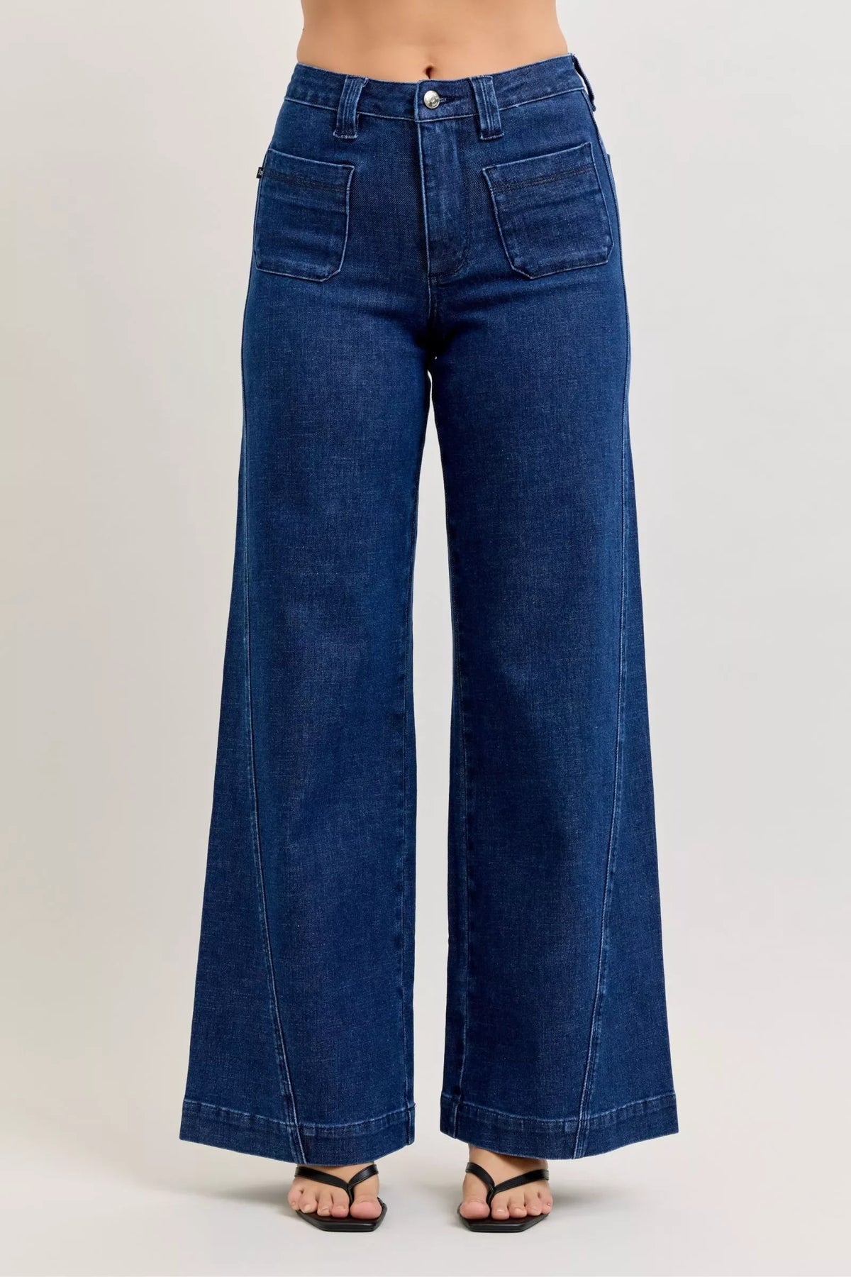 High-waisted wide-leg dark denim jeans with front patch pockets, modeled on a white background.