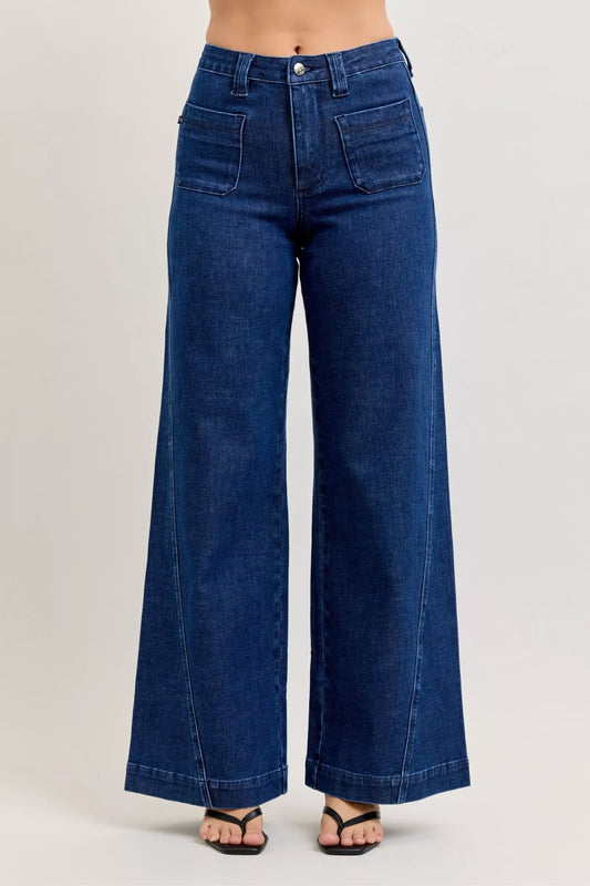 High-waisted wide-leg dark denim jeans with front patch pockets, modeled on a white background.