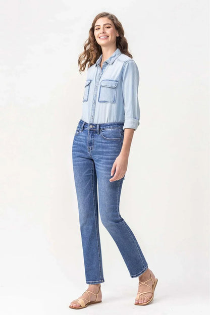 Woman modeling a light denim shirt with front pockets, blue jeans, and tan sandals