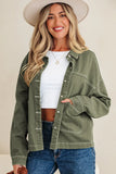Woman in olive green jacket, white crop top, blue jeans, and wide-brim hat