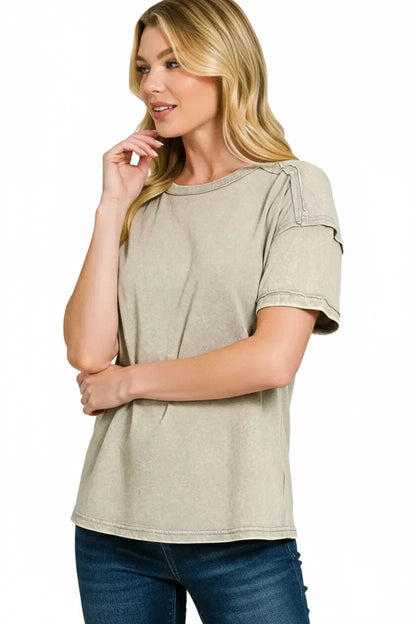 Woman wearing a relaxed fit, beige short sleeve t-shirt and blue jeans on white background.