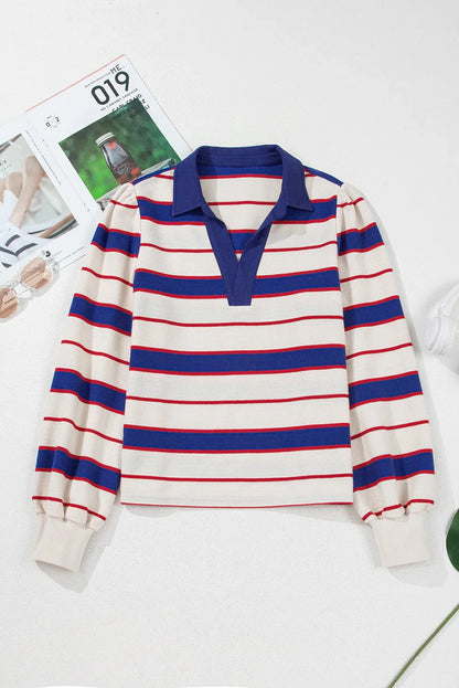 Long sleeve knit top with blue and red stripes, blue collar, and relaxed silhouette on white surface.