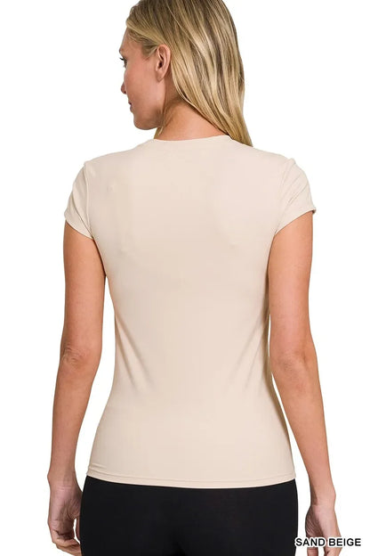 Woman wearing a fitted sand beige short sleeve t-shirt, shown from the back