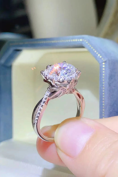 Close-up of a diamond engagement ring with halo setting in a blue velvet box