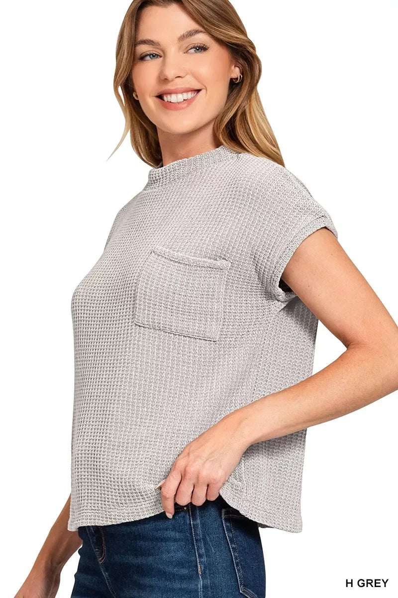 Woman wearing a heather grey waffle knit short sleeve top with chest pocket and jeans
