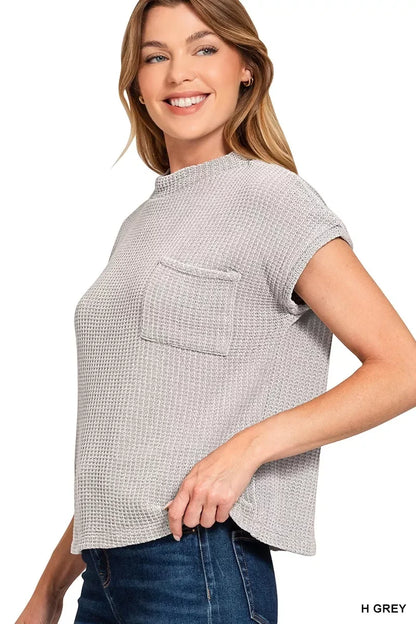 Woman wearing a heather grey waffle knit short sleeve top with chest pocket and jeans