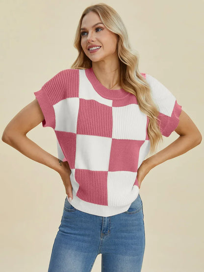 Woman wearing a pink and white checkered short-sleeve knit top with blue jeans