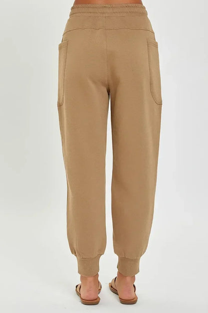 Back view of relaxed fit tan jogger pants with elastic waistband and side pockets