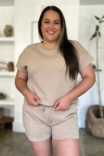 Woman wearing a beige textured short sleeve lounge set with drawstring shorts