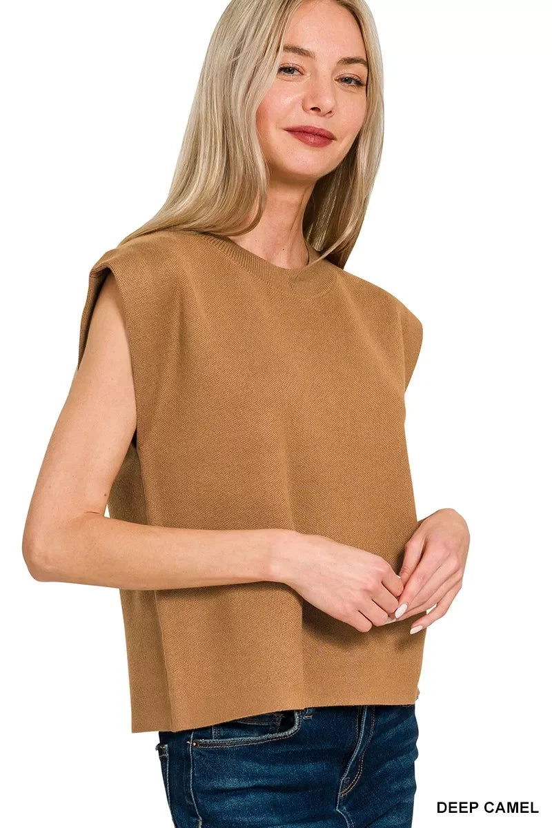 Woman wearing a sleeveless deep camel knit top with relaxed fit and blue jeans