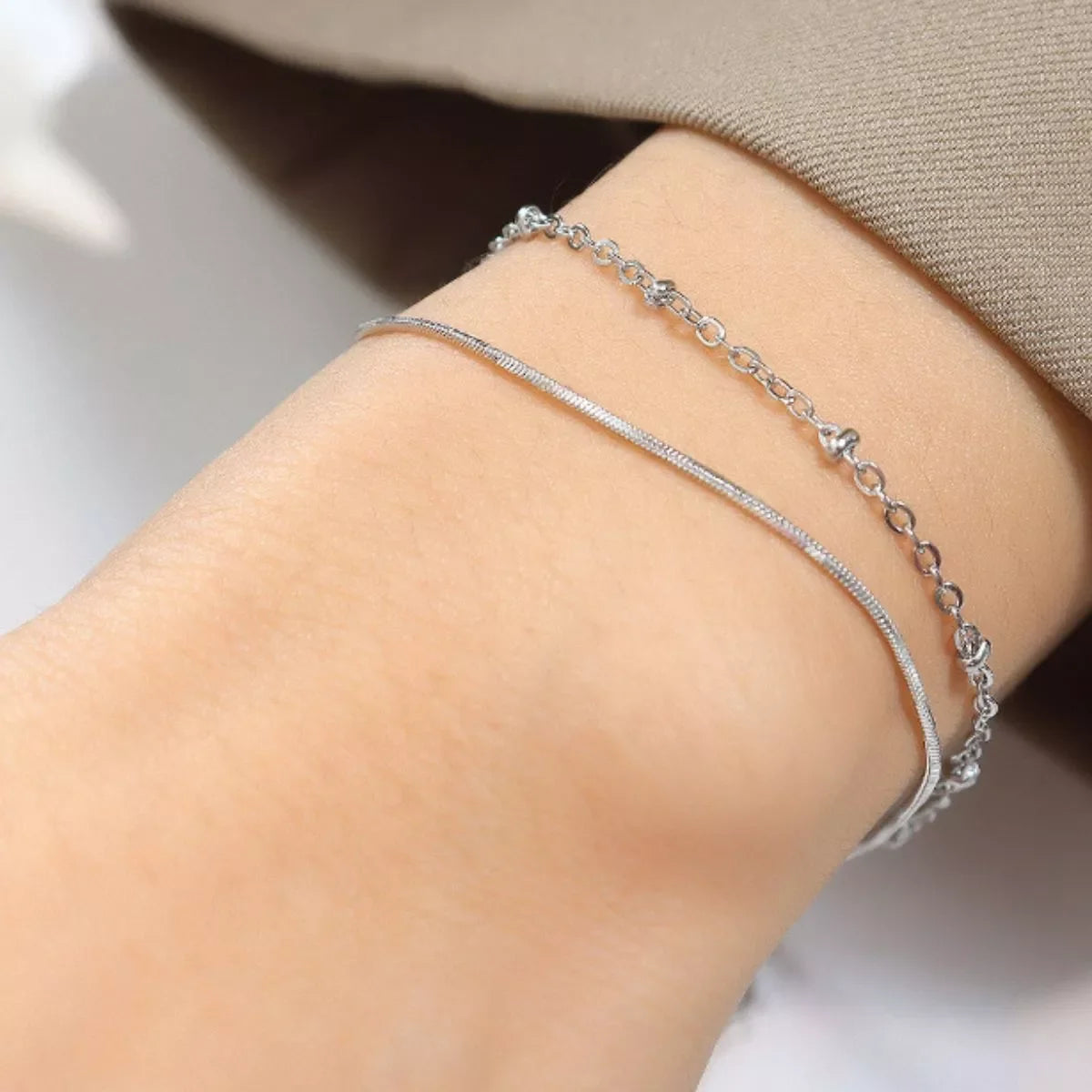 Minimalist silver chain bracelets on wrist, delicate jewelry for women