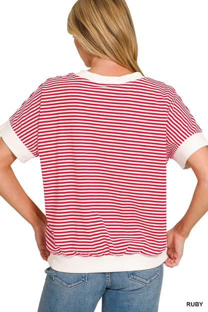 Back view of a woman wearing a red and white striped short sleeve top with white trim.