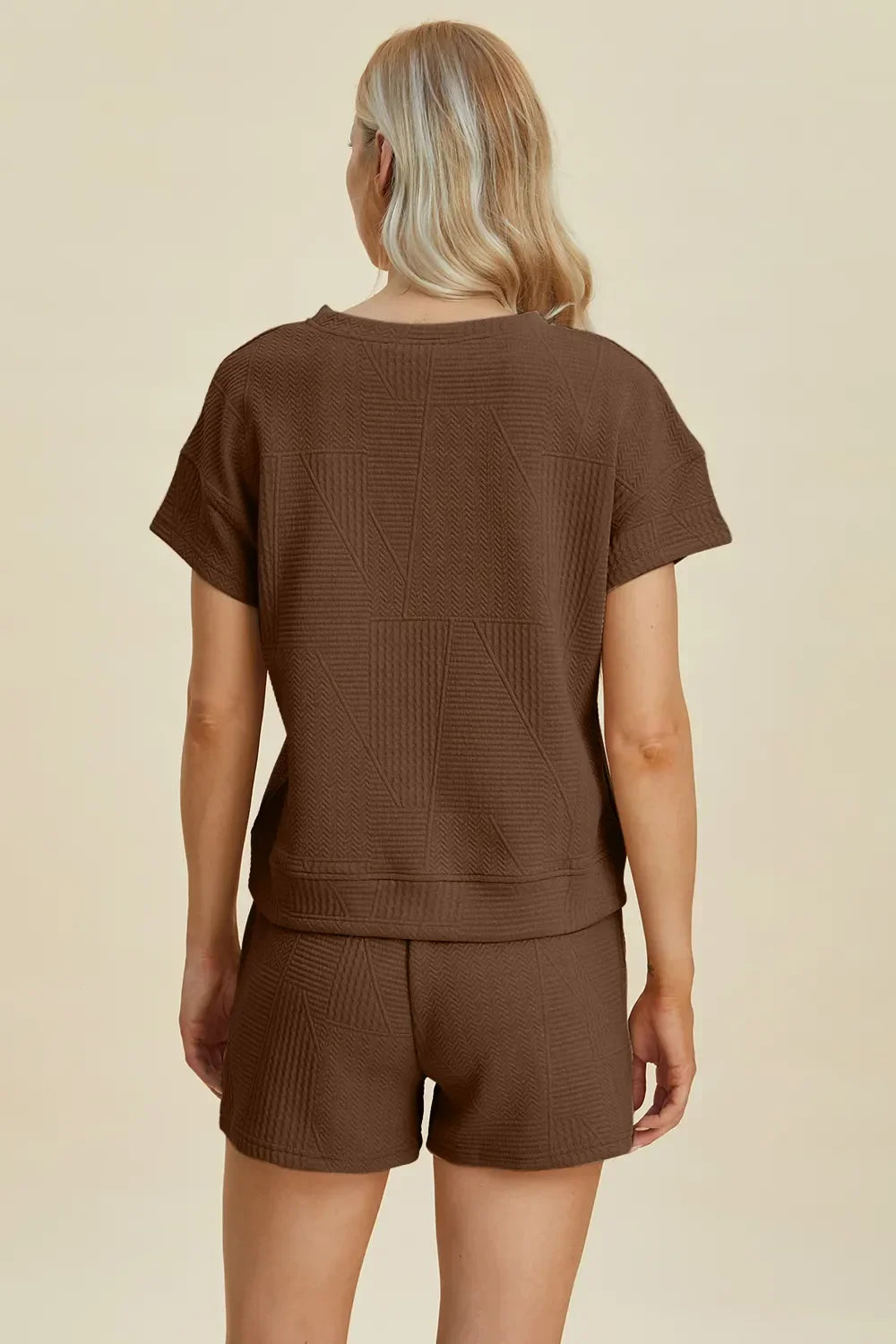 Woman wearing brown textured short-sleeve top and matching shorts, viewed from back