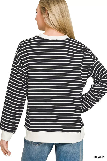 Woman wearing black and white striped long sleeve top with relaxed fit and blue jeans