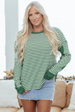Woman in green striped long sleeve top and denim mini skirt, casual living room setting.