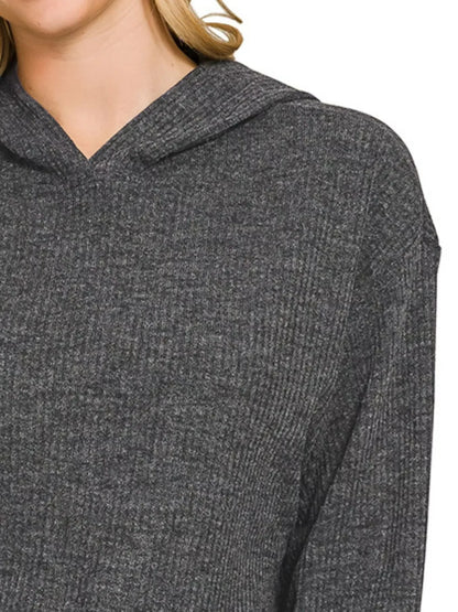 Close-up of a woman wearing a dark grey ribbed knit hooded sweater