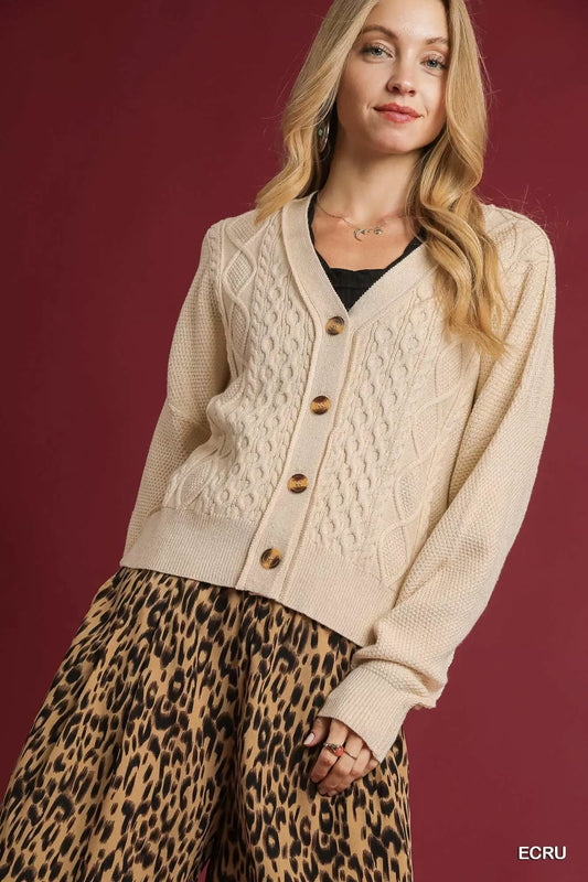 Woman wearing an ecru cable knit cardigan with brown buttons and leopard print skirt