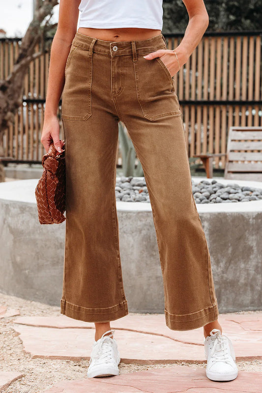 Woman wearing wide-leg brown cropped pants with front patch pockets and white sneakers outdoors