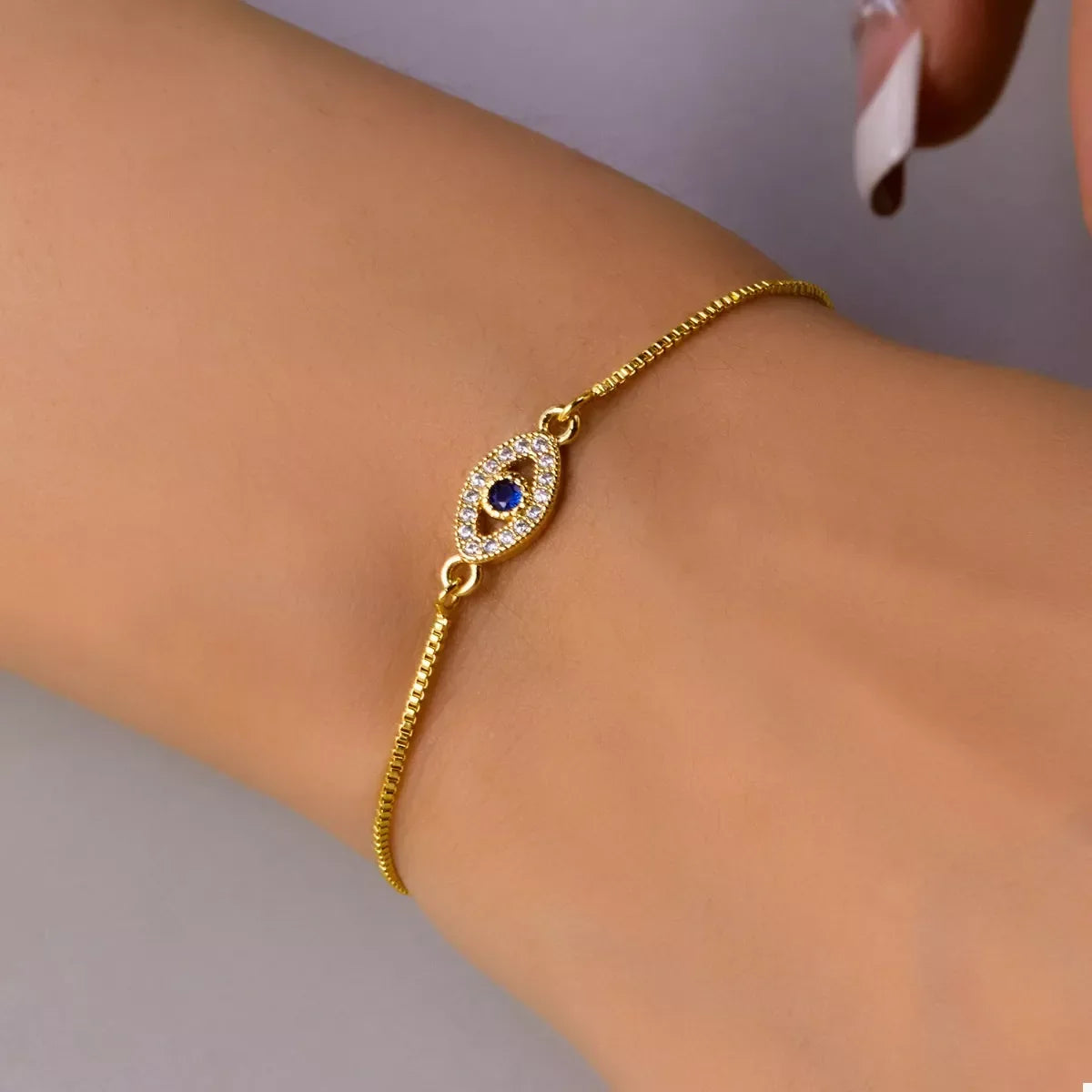 Gold adjustable bracelet with blue gemstone and pavé accent on wrist