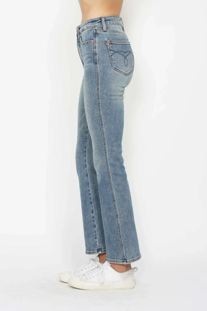 Side view of woman wearing high-waisted straight leg blue jeans and white sneakers