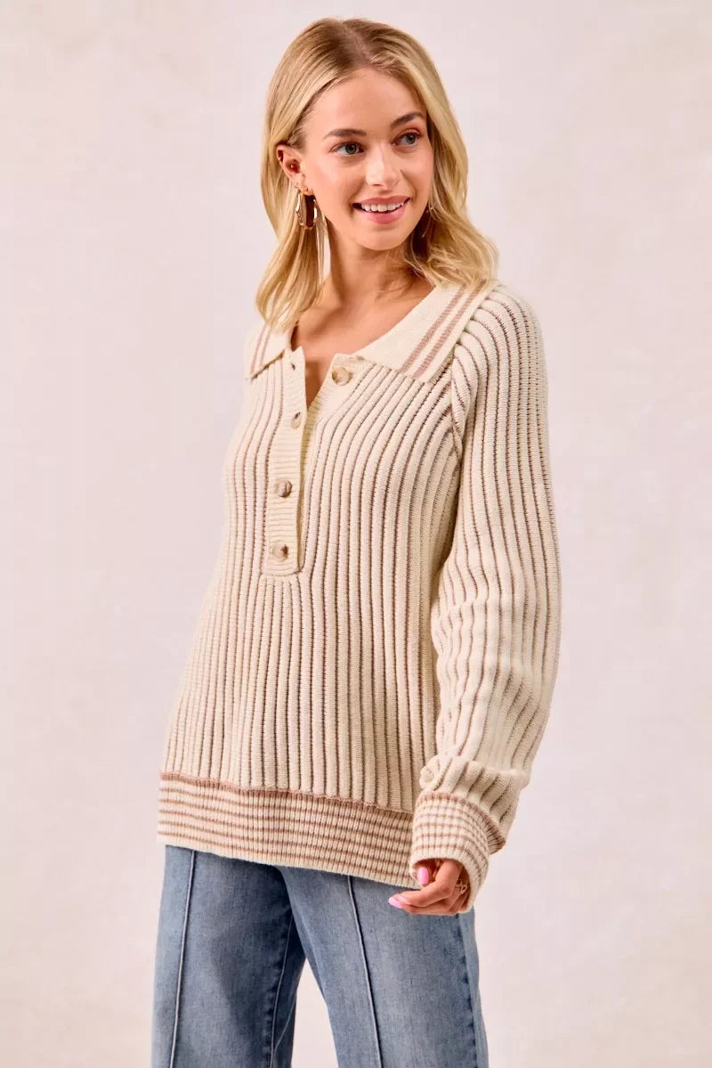 Woman wearing a ribbed beige knit sweater with button placket and relaxed fit jeans