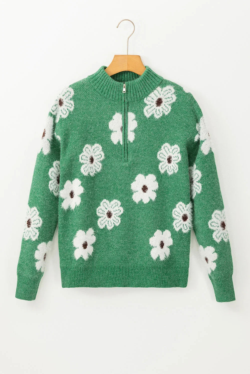 Green knit sweater with white floral pattern and half-zip collar, displayed on hanger