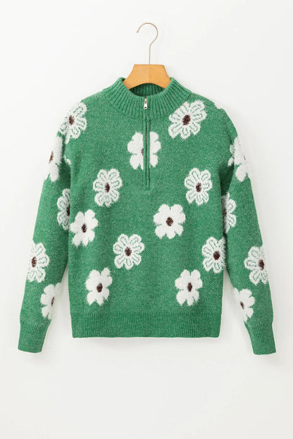 Green knit sweater with white floral pattern and half-zip collar, displayed on hanger